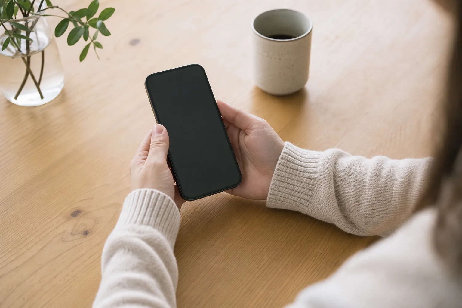 Händer som håller en modern mobiltelefon med eSIM